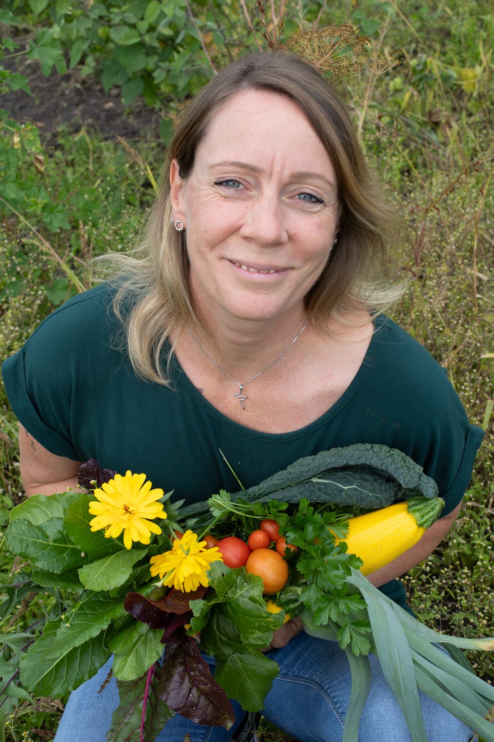 Daniela Müller mit frisch geerntetem Gemüse, Kräutern und Blüten